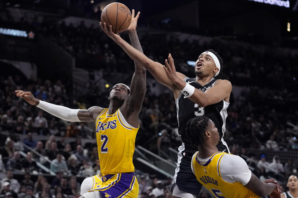 San Antonio Spurs forward Keldon Johnson (3) drives to the basket against Los Angeles Lakers forward Jarred Vanderbilt (2) and forward Cam Reddish (5) during the second half of an NBA basketball game in San Antonio, Wednesday, Dec. 13, 2023. (AP Photo/Eric Gay)