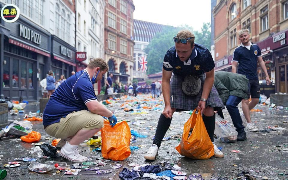 Scotland fans clean up litter in Irving Street near Leicester Square, London, ahead of the UEFA Euro 2020 Group D match between England and Scotland - PA