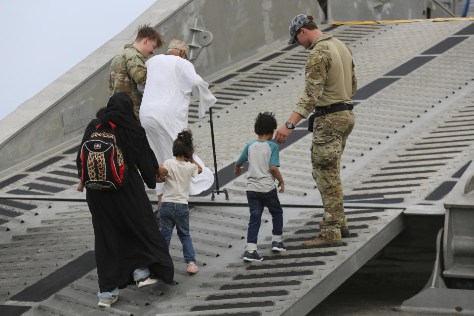 U.S. soldiers escort American nationals to a U.S. Navy ship in Port Sudan, Sunday, April 30, 2023. Sudan's army and its rival paramilitary say they will extend a humanitarian cease-fire another 72 hours as of midnight. The decision follows international pressure to allow the safe passage of civilians and aid but also comes after days of continued fighting despite the earlier truce. (AP Photo/Smowal Abdalla)