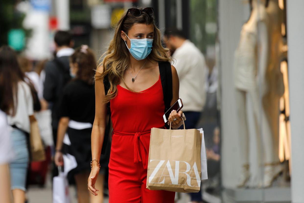 A shopper wears a face mask on Oxford Street om London on July 24, 2020, after wearing facemasks in shops and supermarkets became compulsory in England as a measure to combat the spread of the novel coronavirus. (Photo by Tolga AKMEN / AFP) (Photo by TOLGA AKMEN/AFP via Getty Images)