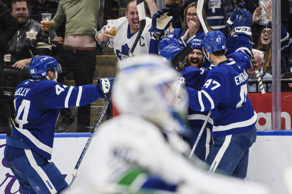 Toronto Maple Leafs defenseman Jordie Benn (18) celebrates with teammates after scoring against the Vancouver Canucks during the second period of an NHL hockey game in Toronto, Saturday, Nov. 12, 2022. (Christopher Katsarov/The Canadian Press via AP)