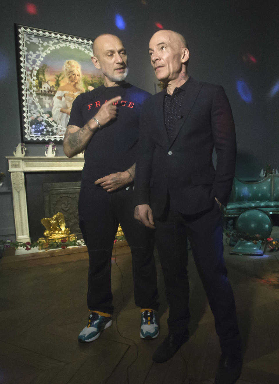 French artists Pierre Commoy, left, and Gilles Blanchard, known as Pierre et Gilles, pose inside their installation at the Gobelins Gallery in Paris, Monday, April 7, 2014. Pierre Commoy and Gilles Blanchard, who have established a strong reputation in Europe and beyond for shock ever since their stylized, hand-painted homoerotic photos first appeared nearly 40 years ago. Today, their iconic images of stars such as Madonna, Kylie Minogue, Mick Jagger and Catherine Deneuve which appear alongside naked gay porn stars in glittering and fantastical scenes line coffee-tables the world over and have titillated millions. (AP Photo/Michel Euler)