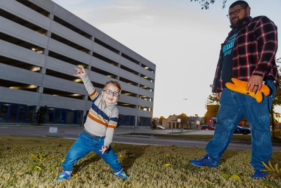 Gabe Nolasco, left, makes Spider-Man gestures while Eric Nolasco, right, stands nearby on the lawn of the Ronald McDonald House at Cook's Children's Medical Center in Fort Worth, Texas on Dec. 2, 2023. Gabe Nolasco, 4, is currently recovering from a thymus transplant as treatment for his congenital athymia.
