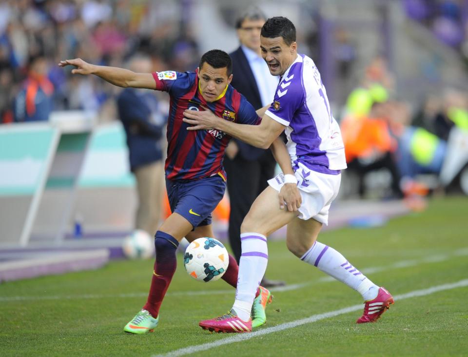 Barcelona's Alexis Sanchez, left, Valladolid's defender Carlos Pena challenge for the ball during a Spanish La Liga soccer match at the Jose Zorrilla stadium in Valladolid, Spain, Saturday March 8, 2014. (AP Photo/Israel L. Murillo)