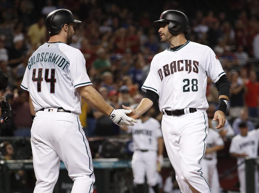 Arizona Diamondbacks’ Paul Goldschmidt (44) greets teammate J.D. Martinez (28) after they scored on a base hit by teammate Brandon Drury against the Los Angeles Dodgers during the first inning of a baseball game, Tuesday, Aug. 29, 2017, in Phoenix. (AP Photo/Matt York)