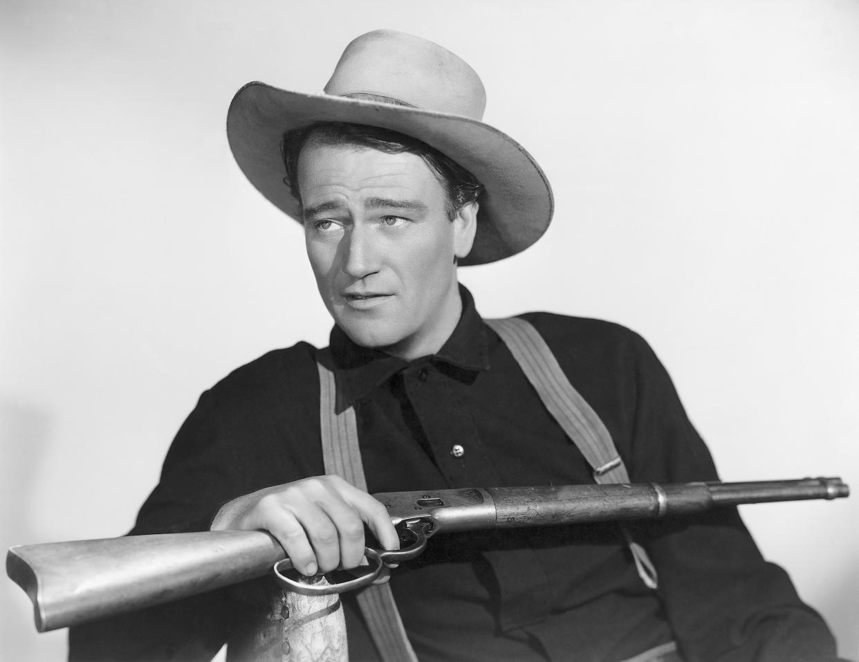 John Wayne holding a rifle in a publicity photo for the movie Shepherd of the Hills.