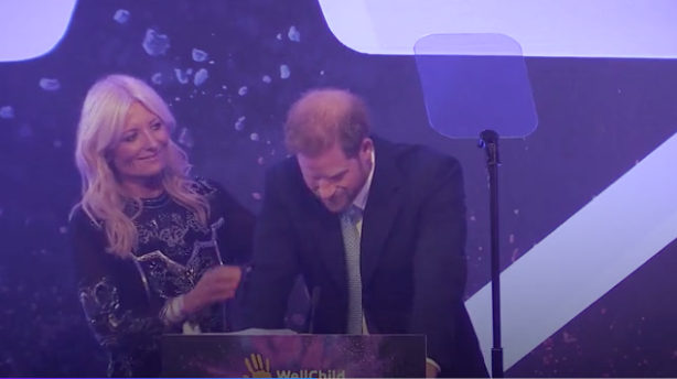 A photo of Britain's Prince Harry, Duke of Sussex tears up on stage alongside television presenter Gaby Roslin as he delivers a speech during the annual WellChild Awards in London on October 15, 2019.