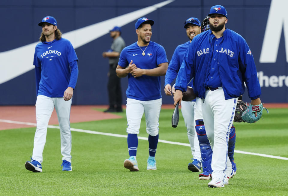 Toronto Blue Jays pitcher Alek Manoah, right, walks to the dugout with fellow pitchers Kevin Gausman, Jose Berrios and Yusei Kikuchi, from left, before the team's baseball game against the Milwaukee Brewers on Wednesday, May 31, 2023, in Toronto. (Frank Gunn/The Canadian Press via AP)