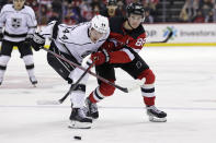 New Jersey Devils center Jack Hughes (86) and Los Angeles Kings defenseman Mikey Anderson battle for the puck during the second period of an NHL hockey game Sunday, Jan. 23, 2022, in Newark, N.J. (AP Photo/Adam Hunger)