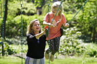 Holly Christensen, left, pushes her daughter, Lyra, on a swing, Thursday, May 13, 2021, in Akron, Ohio. Anti-abortion activists say 2021 has been a breakthrough year for legislation in several states seeking to prohibit abortions based on a prenatal diagnosis of Down syndrome. Opponents of the bills, including some parents with children who have Down syndrome like Holly, argue that elected officials should not be meddling with a woman’s deeply personal decision on whether to carry a pregnancy to term after a Down syndrome diagnosis. (AP Photo/Tony Dejak)