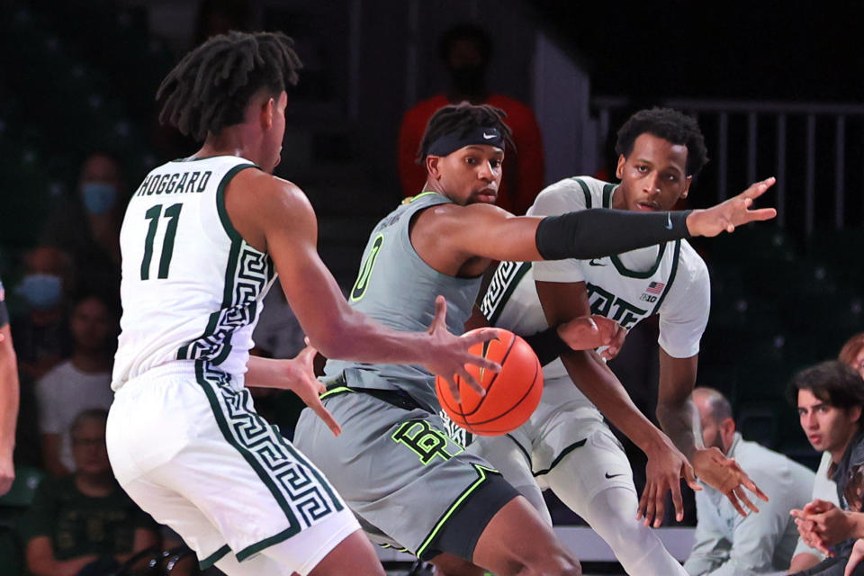 In this photo provided by Bahamas Visual Services, Michigan State's Marcus Bingham Jr., right, passes the ball to guard A.J. Hoggard (11) as Baylor's Flo Thamba defends during an NCAA college basketball game at Paradise Island, Bahamas, Friday, Nov. 26, 2021. (Tim Aylen/Bahamas Visual Services via AP)