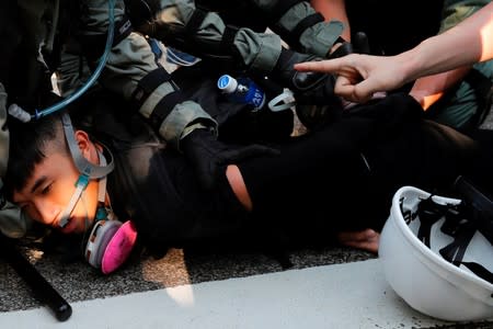 Anti-government protester is detained during a march in Tuen Mun, Hong Kong