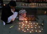Afghan men light candles for Japanese doctor Tetsu Nakamura, who was killed in Jalalabad in yesterday's attack, in Kabul