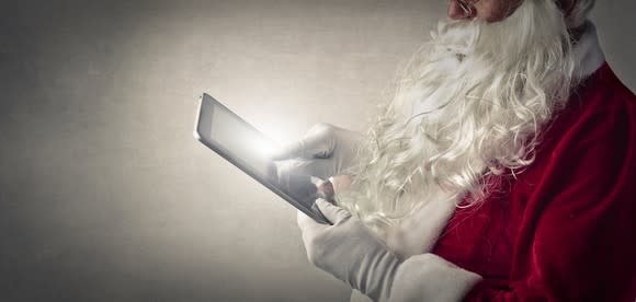 Santa Claus using a tablet.