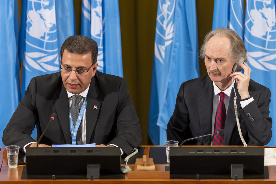 Constitutional Committee Co-Chairman Ahmad Kuzbari, left, representative of the Syrian Government, and Geir O. Pedersen, right, Special Envoy for Syria, speak during the first meeting of the Syrian Constitutional Committee at the European headquarters of the United Nations in Geneva, Switzerland, Wednesday, October 30, 2019. (Martial Trezzini/Keystone via AP)