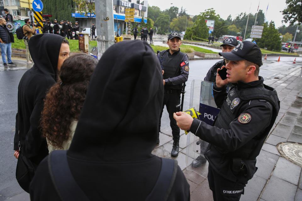 A Turkish policeman talks to passers-by in a cordoned off area after an explosion in Ankara, Sunday, Oct. 1, 2023. A suicide bomber detonated an explosive device in the heart of the Turkish capital, Ankara, on Sunday, hours before parliament was scheduled to reopen after a summer recess. A second assailant was killed in a shootout with police. (AP Photo/Ali Unal)