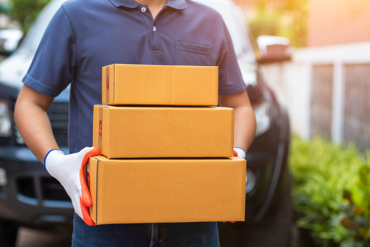 Delivery asian man holding cardboard boxes in medical rubber gloves and mask. Online shopping and Express delivery, or ecommerce. concept prevent the spread of germs and avoid infections Covid-19