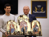 Serbian tennis player Novak Djokovic, left, poses with top local official Marko Carevic during a ceremony in the municipal building in Budva, Montenegro, Friday, Jan. 28, 2022. Djokovic arrived to receive a plaque declaring him an honorary citizen of the town. (AP Photo/Risto Bozovic)