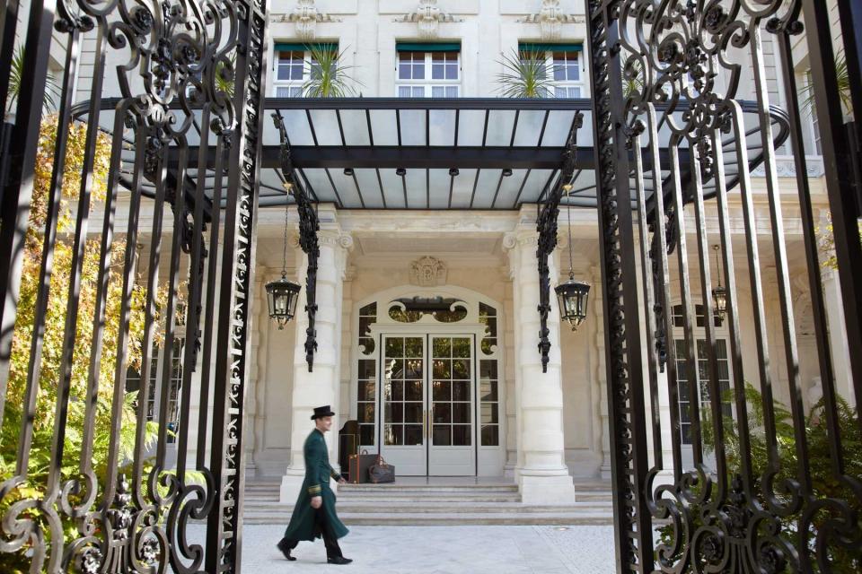 A staff member walks past the entrance of the Shangri-La Hotel in Paris