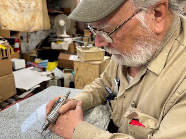 In his Lambertville workshop, Leo LeClair transforms a granite headstone into a loving memory of a customer's deceased loved one.