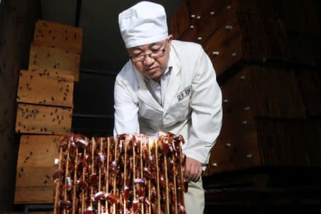 A staff member shows cockroaches in shelves to the camera at a farm operated by pharmaceutical company Gooddoctor in Xichang, Sichuan province, China August 10, 2018.  REUTERS/Thomas Suen