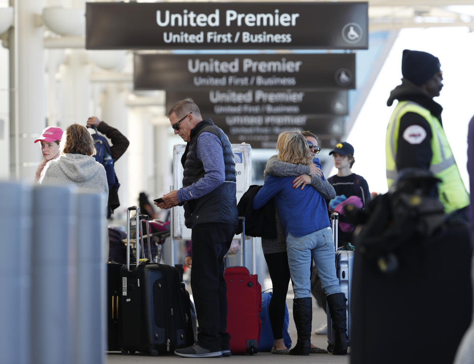 Women exchange farewells at the curbside baggage checkpoint outside the west gates of Denver International Airport, Wednesday, Nov. 21, 2018, in Denver. Mild weather in parts of the country and lower gasoline prices have potentially created one of the busiest Thanksgiving Day travel periods since 2005, according to AAA. (AP Photo/David Zalubowski)