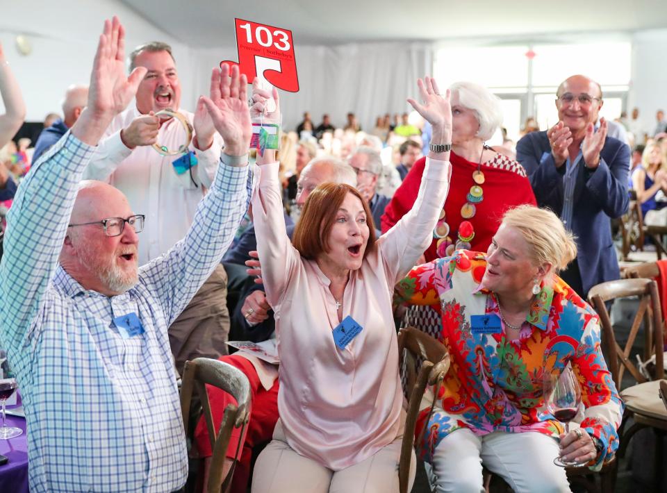 Naples Children and Education Foundation Trustee Grace Evenstad, center, raises her hands after winning a lot during the 2023 Naples Winter Wine Fest at The Ritz-Carlton Golf Resort in Naples on Saturday, Feb. 4, 2023.