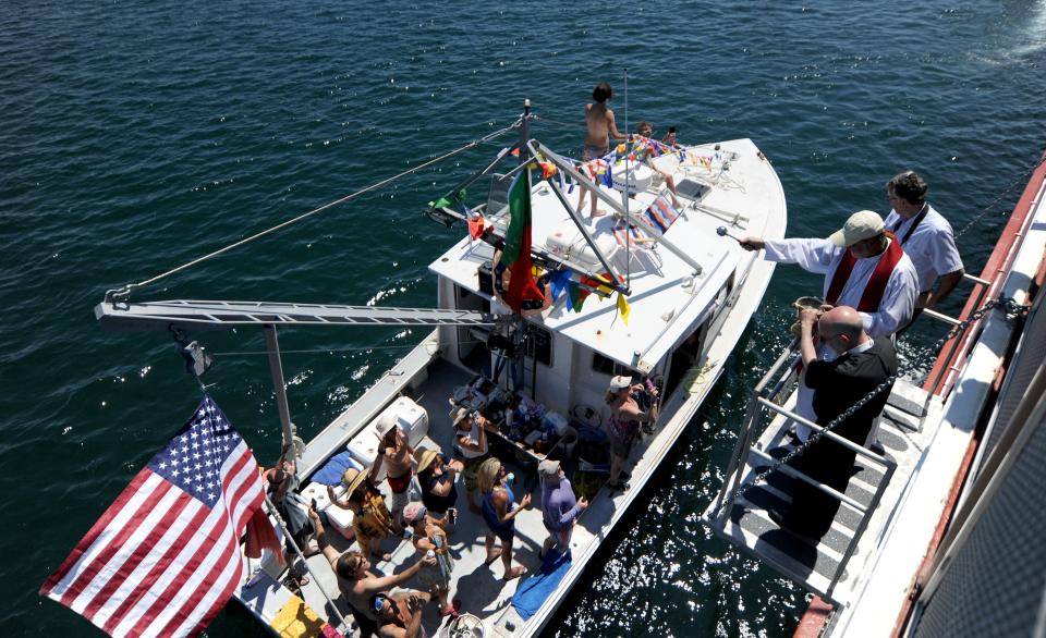 Bishop Edgar M. da Cunha sprinkles holy water onto Michael Packard's boat, the Ja'n J. Packard, of Wellfleet, is the lobster diver who had an encounter with a humpback whale last year where he was taken whole into its mouth and spit back out.