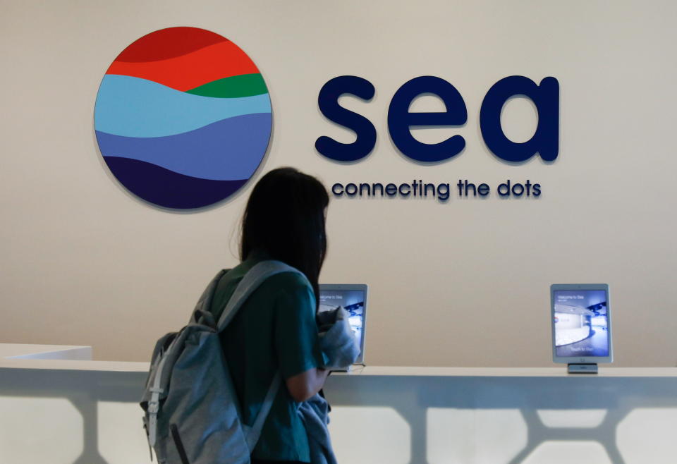 A person stands in front of a signage of Southeast Asian e-commerce and gaming group Sea Ltd's