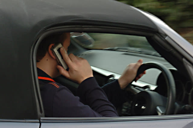 Embargoed to 0001 Friday November 25 POSED BY MODEL Undated file photo of a man using his mobile phone while driving, as a new study suggests that fewer than three in five (59\%) people would ask a driver to stop using a hand-held mobile phone if they were a passenger in the car.