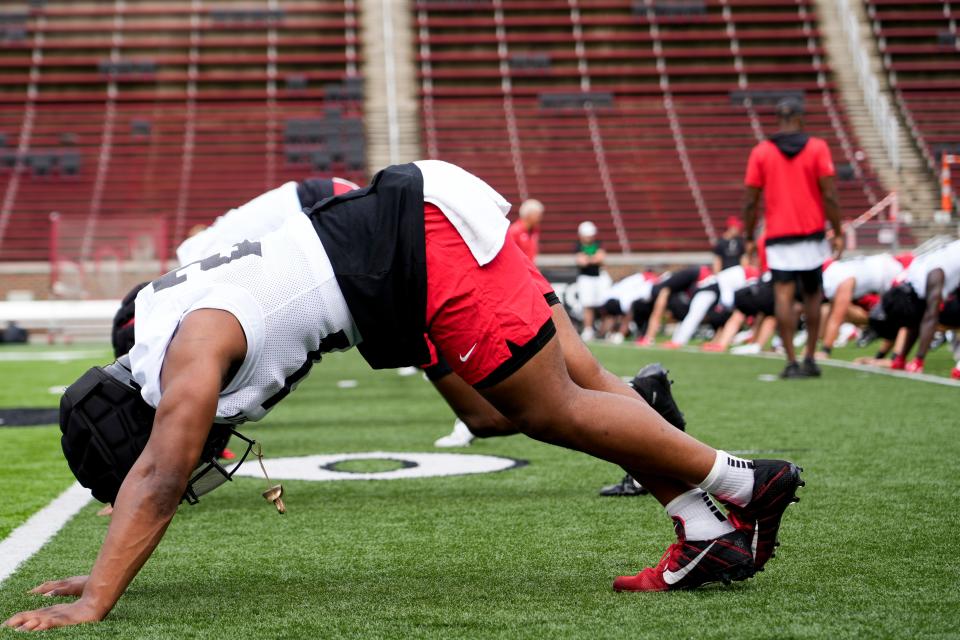 Cincinnati Bearcats players participate in a stretching routine during football practice, Wednesday, July 31, 2024, at Nippert Stadium in Cincinnati.