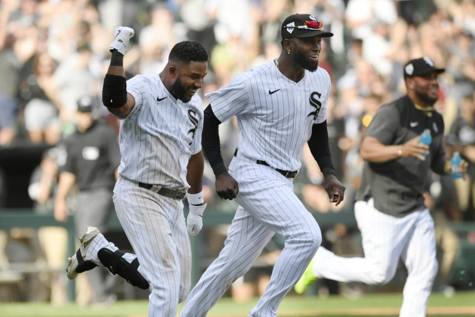 Chicago White Sox's Elvis Andrus left, and Luis Robert right, celebrate while running on the field after teammate Oscar Colas hit a walk-off RBI single to defeat the Baltimore Orioles 7-6 in 10 innings in a baseball game Saturday, April 15, 2023, in Chicago. (AP Photo/Paul Beaty)