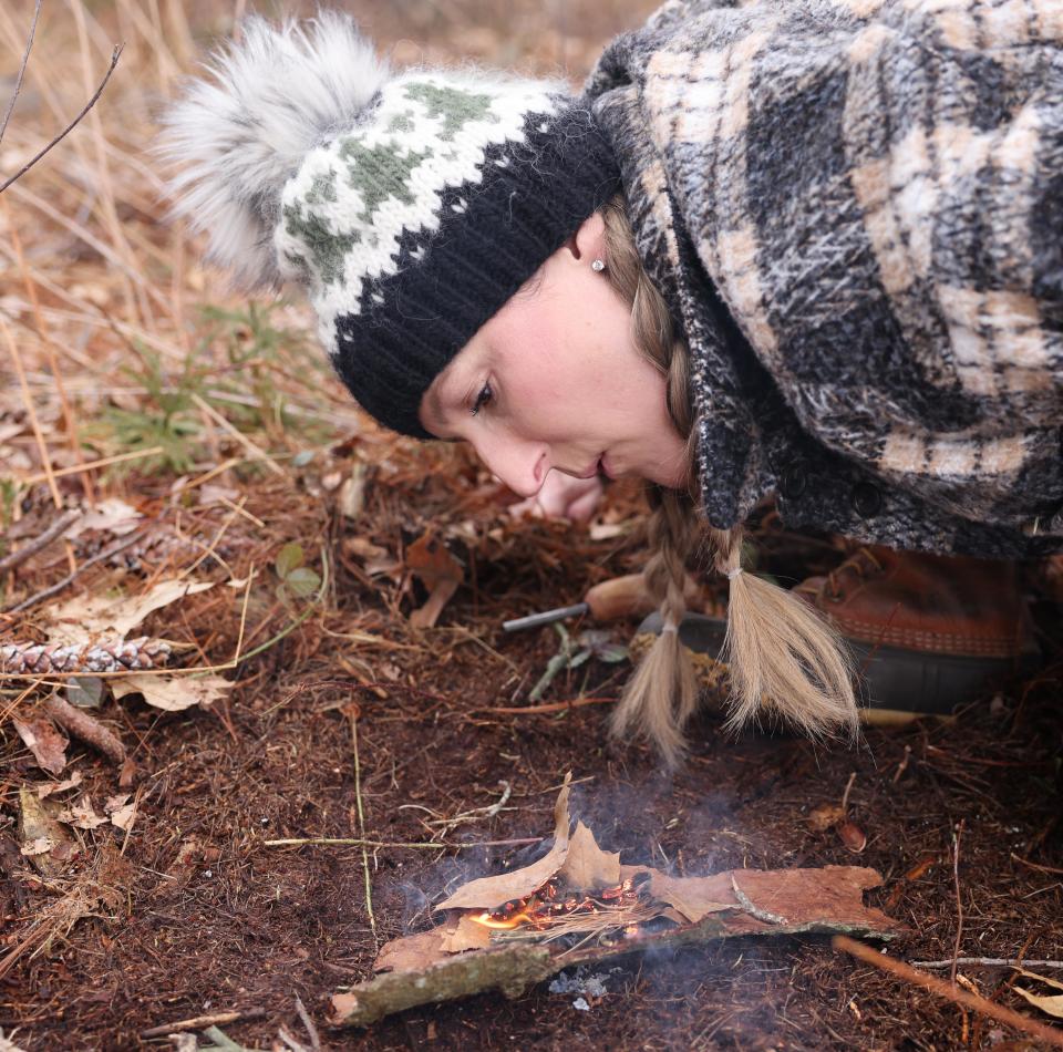 Survivalist Megan Krugger, a local science teacher, uses a fire starter at her East Bridgewater farm, Mistletoe Acres Tree Farm, on Saturday, March 9, 2024. She recently appeared on the Discover Channel's "Naked and Afraid."