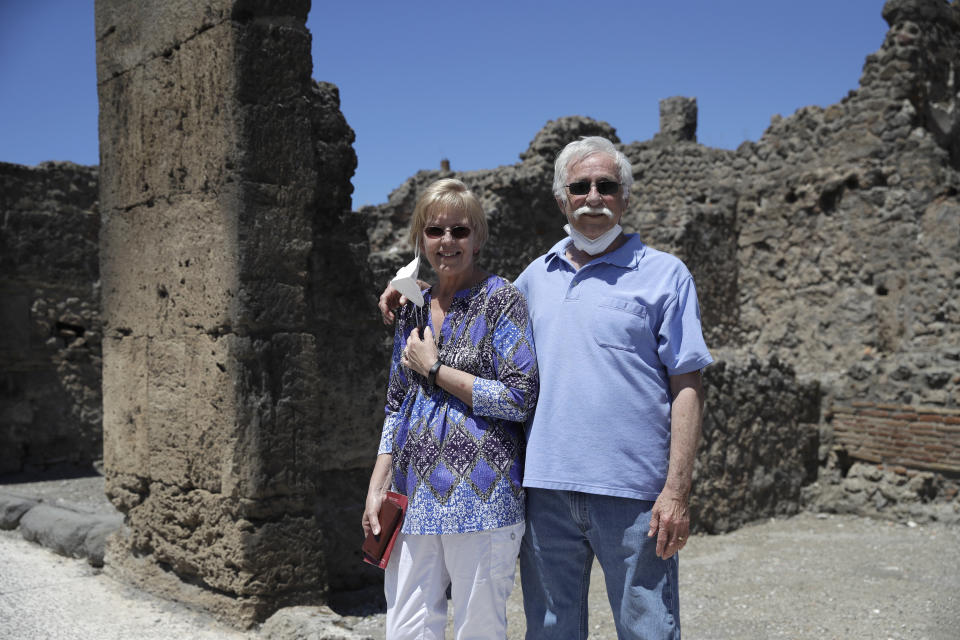 Colleen and Marvin Hewson, from the United States, pose for a photograph during their visit to the archeological sites of Pompeii, near Naples, southern Italy, Tuesday, May 26, 2020. An American couple waited a lifetime plus 2 ½ months to visit the ancient ruins of Pompeii together. For Colleen and Marvin Hewson, the visit to the ruins of an ancient city destroyed in A.D. 79 by a volcanic eruption was meant to be the highlight a trip to celebrate his 75th birthday and their 30th anniversary. They were among the only tourists present when the archaeological site reopened to the public on Tuesday after the national lockdown to prevent the spread of COVID-19. (AP Photo/Alessandra Tarantino)