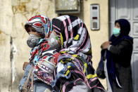 People wear masks to help guard against the Coronavirus in downtown Tehran, Iran, Sunday, Feb. 23, 2020. On Sunday Iran's health ministry raised the death toll from the new virus to 8 people in the country, amid concerns that clusters there, as well as in Italy and South Korea, could signal a serious new stage in its global spread. (AP Photo/Ebrahim Noroozi)