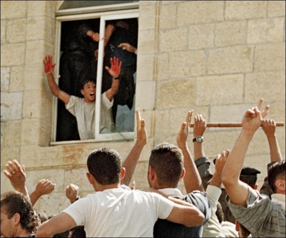 A Palestinian showing his red hands after two Israeli reservists were lynched by a mob in Ramallah on Oct. 12, 2000. Photo by CHRIS GERALD/AFP via Getty Images