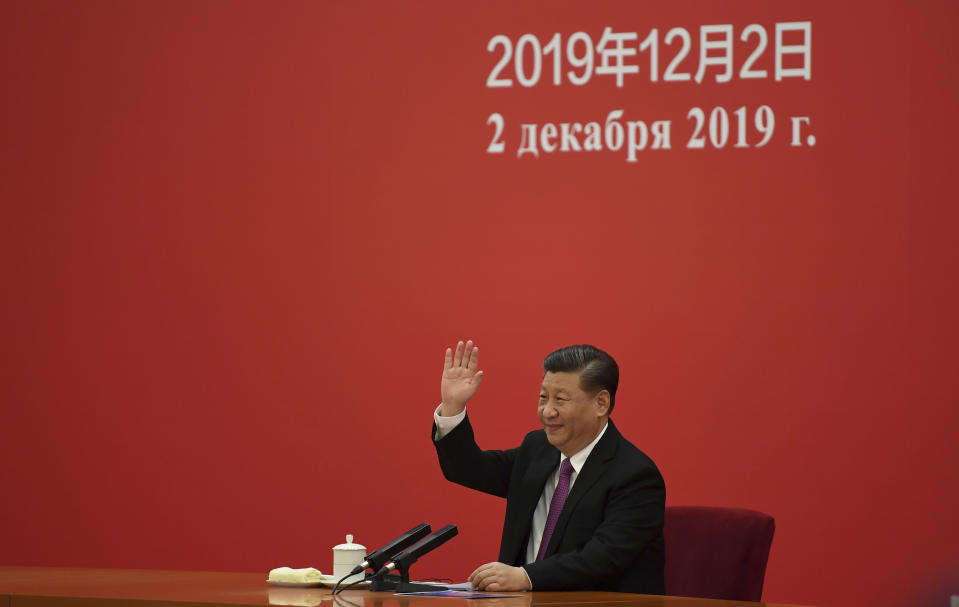 China's President Xi Jinping waves to Russian President Vladimir Putin via a video link from the Great Hall of the People in Beijing, Monday, Dec. 2, 2019. (Noel Celis/Pool Photo via AP)
