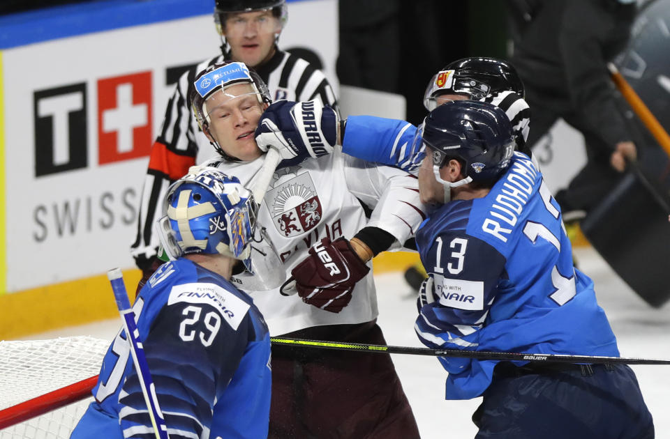 Finland's Mikael Ruohomaa, right, scuffles with Latvia's Andris Dzerins during the Ice Hockey World Championship group B match between Finland and Latvia at the Arena in Riga, Latvia, Sunday, May 30, 2021. (AP Photo/Sergei Grits)