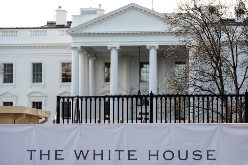 The new fence surrounding the White House is seen behind a screen in Washington