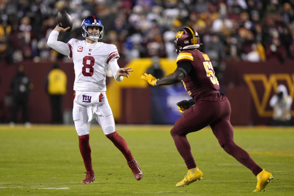 New York Giants quarterback Daniel Jones (8) throws the ball as he is chased by Washington Commanders linebacker Jamin Davis (52) during the second half of an NFL football game, Sunday, Dec. 18, 2022, in Landover, Md. (AP Photo/Susan Walsh)