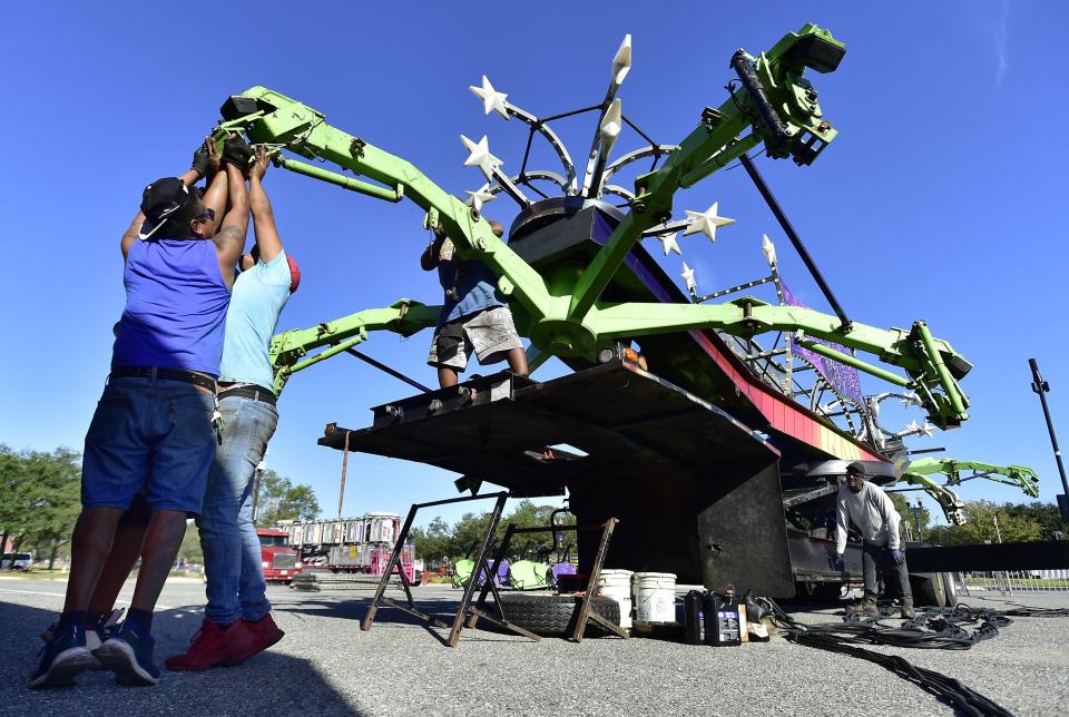 Carnival workers start the set-up process for the Scorpion ride for the Jacksonville Fair last November in the sports complex in downtown Jacksonville. The annual fair has been a tradition since 1955.