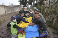 Indonesian rescuers and villagers evacuate a victim on a car in an area affected by the eruption of Mount Semeru in Lumajang, East Java, Indonesia, Sunday, Dec. 5, 2021. The highest volcano on Indonesia’s most densely populated island of Java spewed thick columns of ash, searing gas and lava down its slopes in a sudden eruption triggered by heavy rains on Saturday. (AP Photo/Trisnadi)