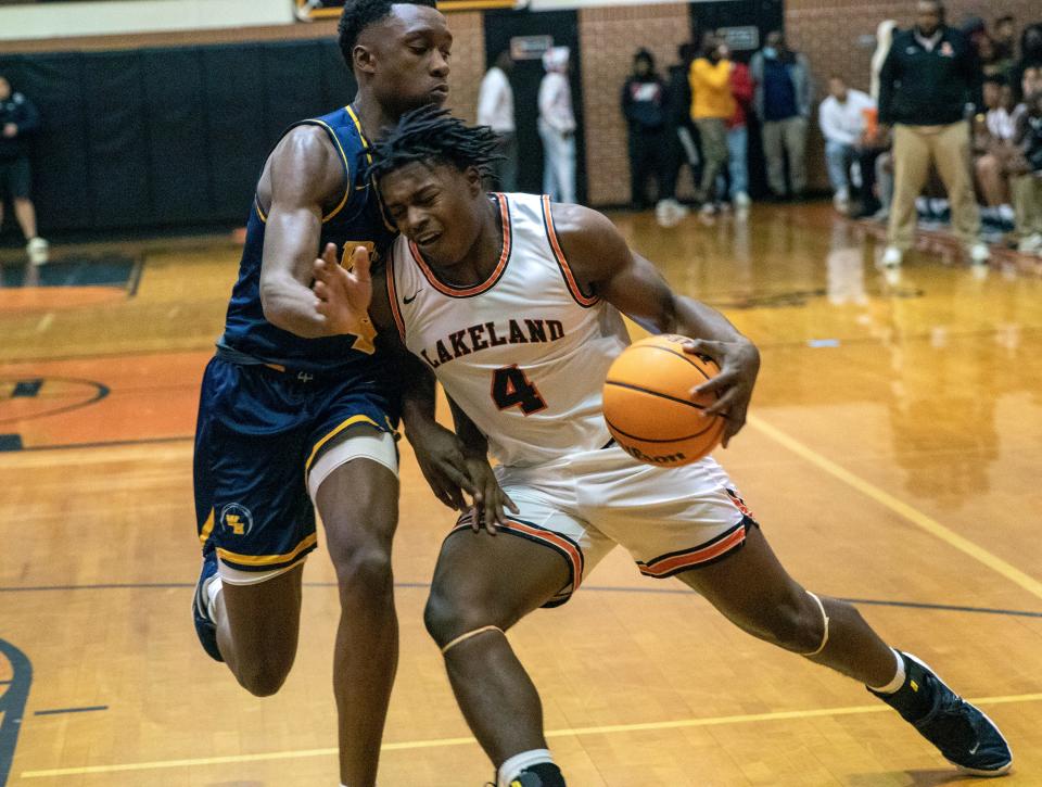Lakeland's Rolijah Hardy (4) drives to the basket as he is defended by Winter Haven's Isaac Celiscar (4).