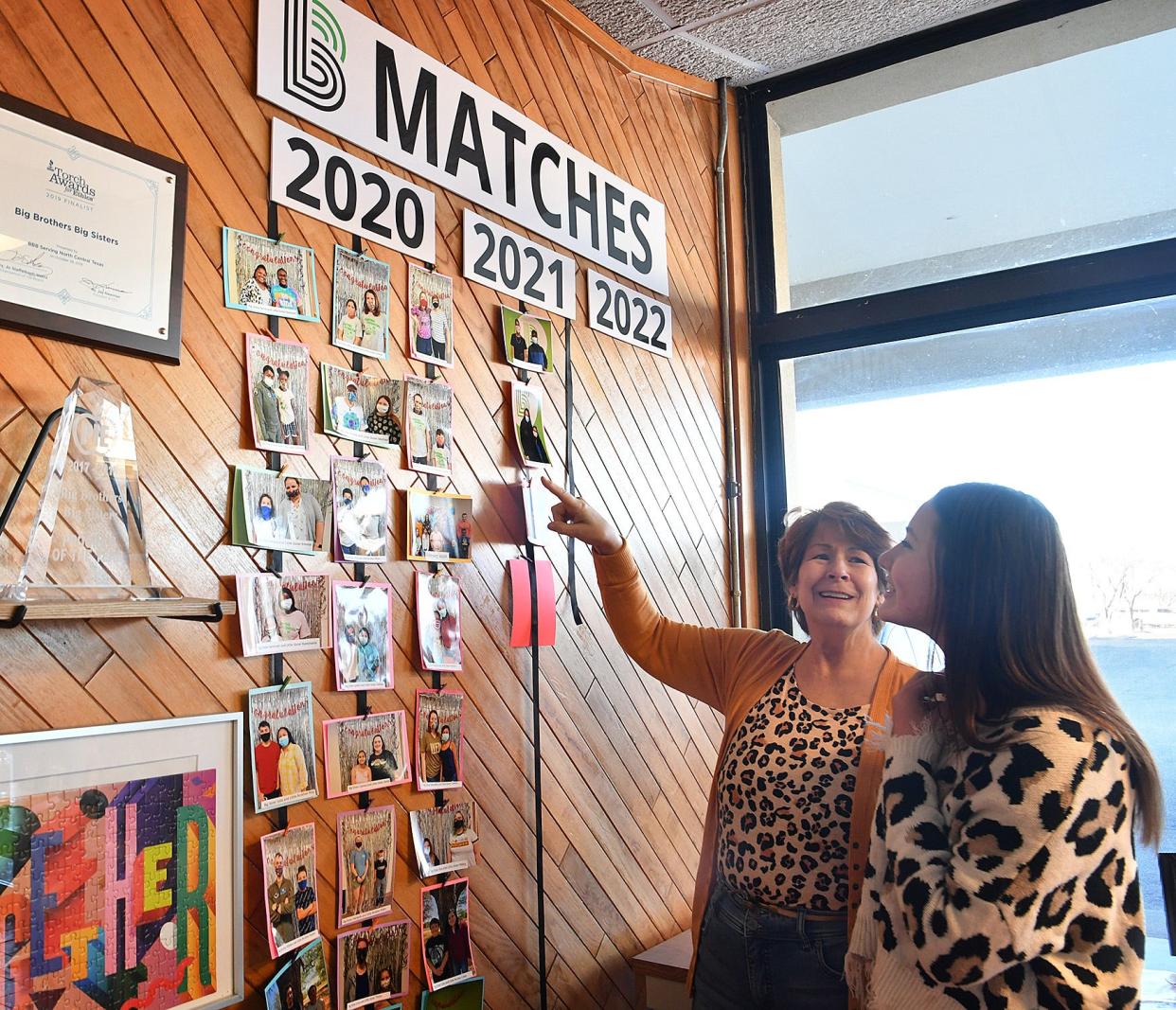 Brianna Mendieta, right, and Sandra Brooks, check out photos of other Big Brothers Big Sisters matches like theirs. The City View student and the retiree were matched about two years ago and get along great.