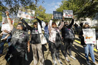 Abortion rights advocates hold up signs in an effort to block the view of anti-abortion protesters at a rally in Jackson, Miss., Wednesday, Dec. 1, 2021. The U.S. Supreme Court on Wednesday heard a Mississippi case that directly challenges the constitutional right to an abortion established nearly 50 years ago. (AP Photo/Rogelio V. Solis)