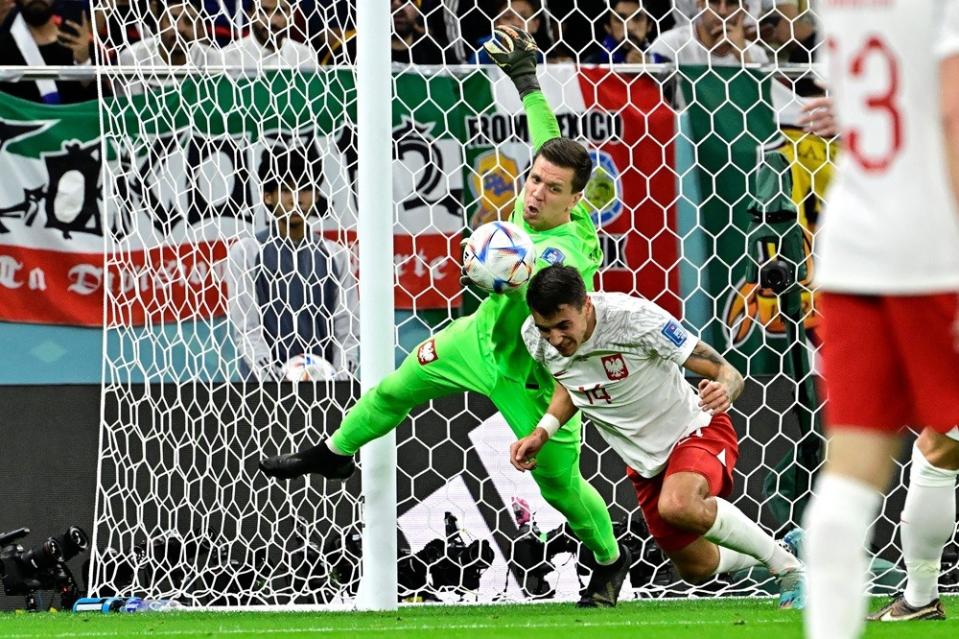 Poland's Wojciech Szczesny (L) punches the ball ahead of Jakub Kiwior during the Qatar 2022 World Cup round of 16 football match between France and Poland at the Al-Thumama Stadium in Doha on December 4, 2022. (Photo by JAVIER SORIANO/AFP via Getty Images)