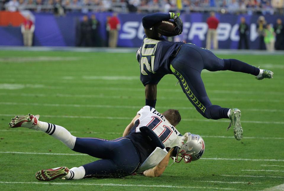 Seattle Seahawks cornerback Lane is tackled by New England Patriots wide receiver Edelman after making a first quarter interception during the NFL Super Bowl XLIX football game in Glendale