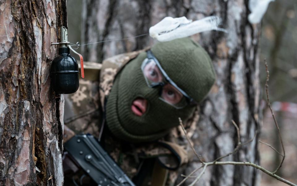 A member of the Ukrainian Legion navigates a grenade booby trap during a weekend training exercise outside Kyiv - Shutterstock
