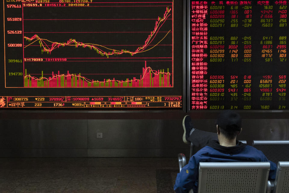 In this Thursday, Jan. 16, 2020, photo, an investor monitors stock prices at a brokerage in Beijing. Asian stock markets on Friday, Jan. 17 have followed Wall Street higher after China reported its economy grew by 6.1% in 2019 and Washington and Beijing signed an interim trade agreement. (AP Photo/Ng Han Guan)