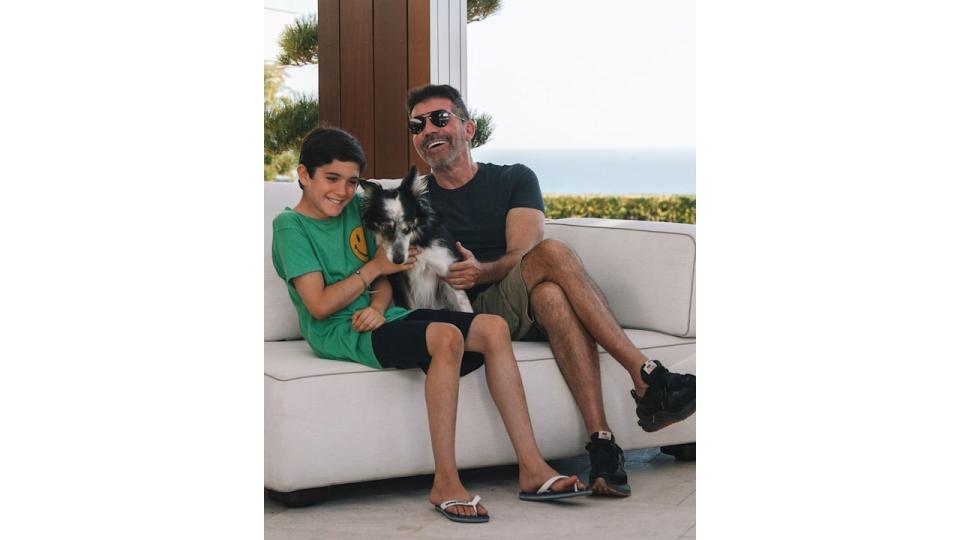 Simon Cowell and his son cuddling a dog